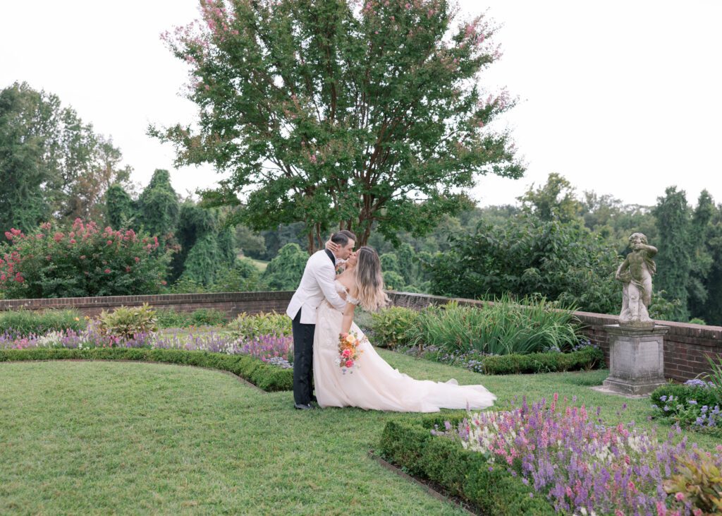 Newly married couple kisses in the garden at Oxon Hill Manor just outside of Washington DC