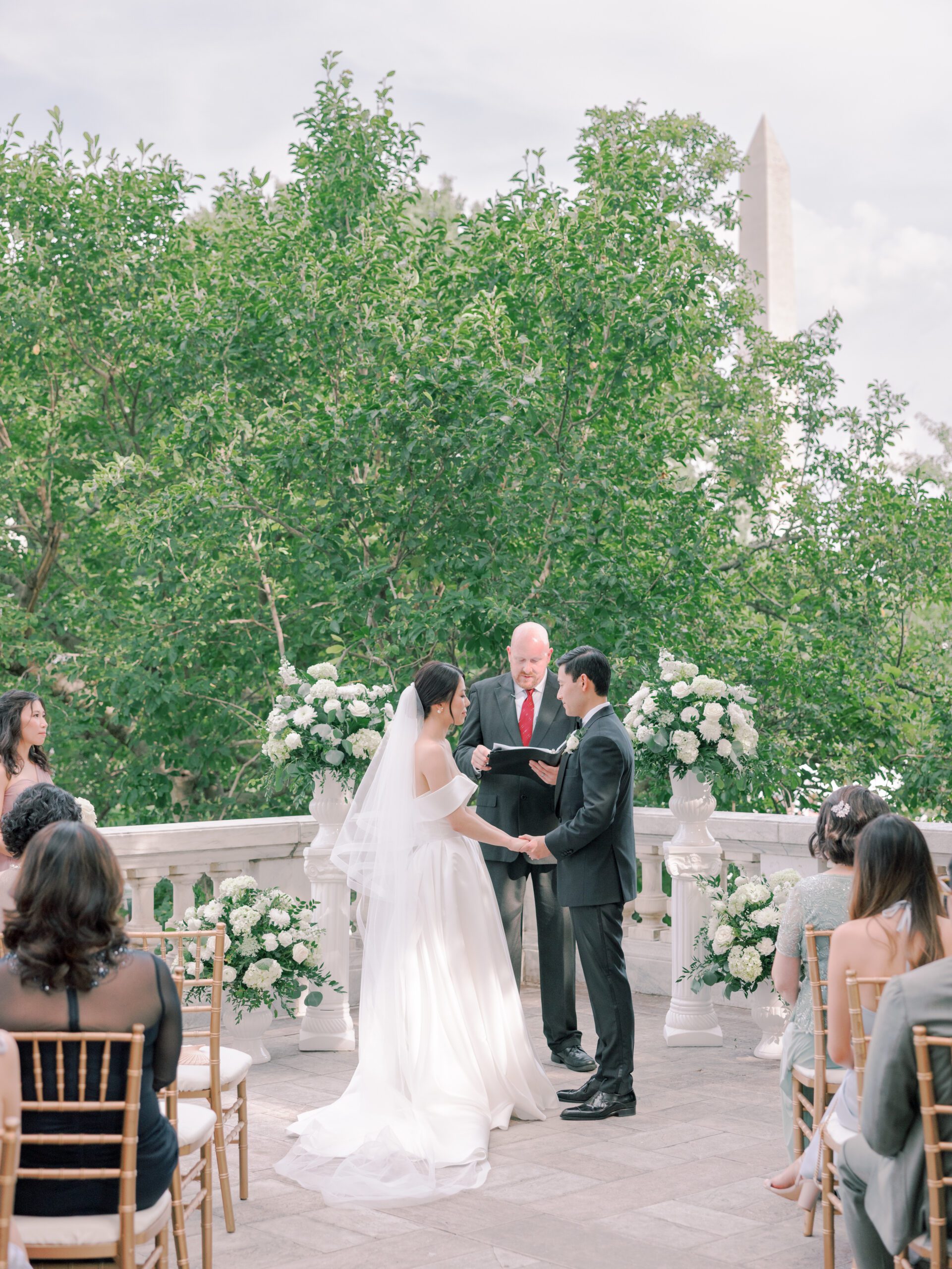 A bride and groom exchange wedding vows at the DAR in Washington DC with the Washington Monument in the background