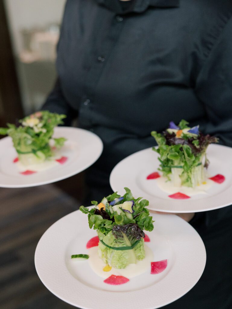 Three beautifully plated, colorful salads with edible flowers being served at one of the best restaurants in Northern Virginia